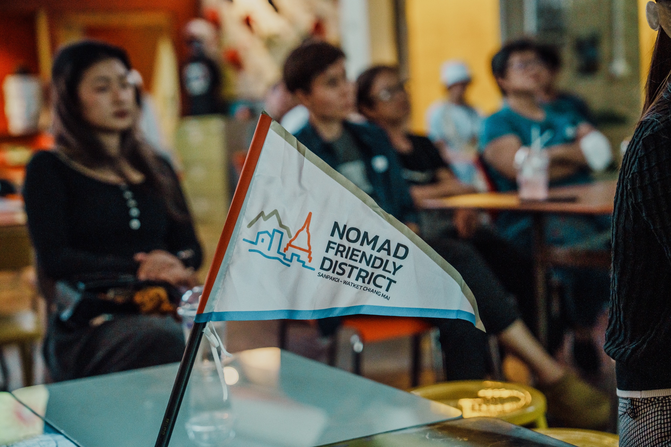 Nomad Friendly District pennant flag for Sanpakoi and Wat Ket on a table during a community meeting in Chiang Mai